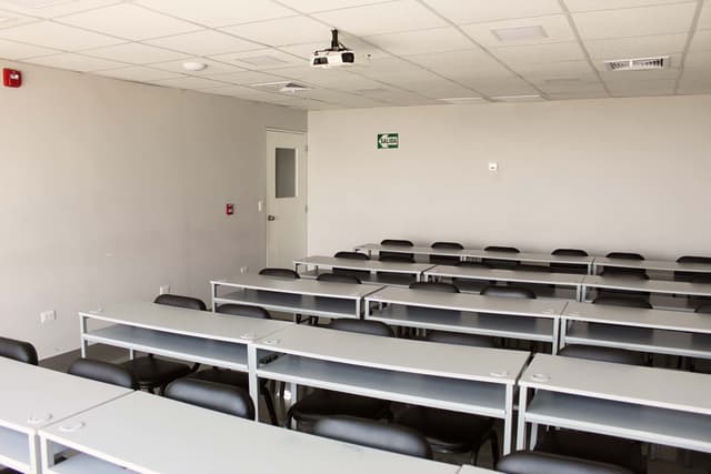 Sala equipada para capacitación con mesas y sillas